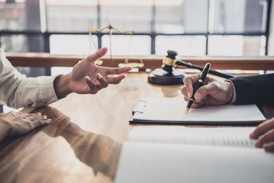 A gavel and scales on the table as sale documents are signed